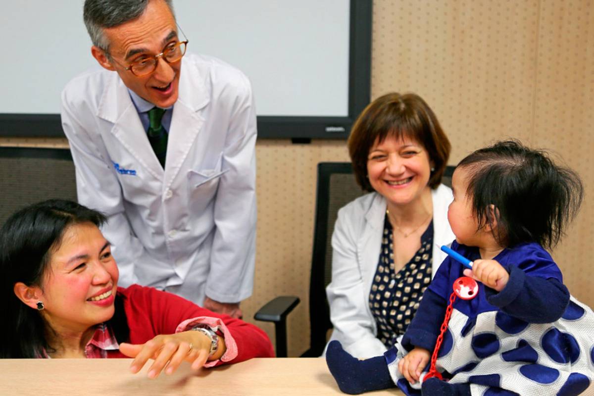 Los neuropediatras Alfons Macaya y Francina Munell, del VHIR, con una paciente (y su madre) tratada con terapia génica